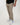 Tall man wearing beige pants with black T-shirt and white sneakers