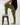 Tall man wearing olive green tapered pants with black T-shirt and sneakers