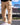Tall man wearing beige Wadlow cargo pants outdoors, close-up view.