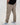 Tall man wearing beige pants with black shirt and white sneakers
