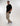 Tall man modeling a black T-shirt with beige pants and white sneakers