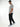 Tall man in profile wearing black pants with light grey T-shirt and sneakers